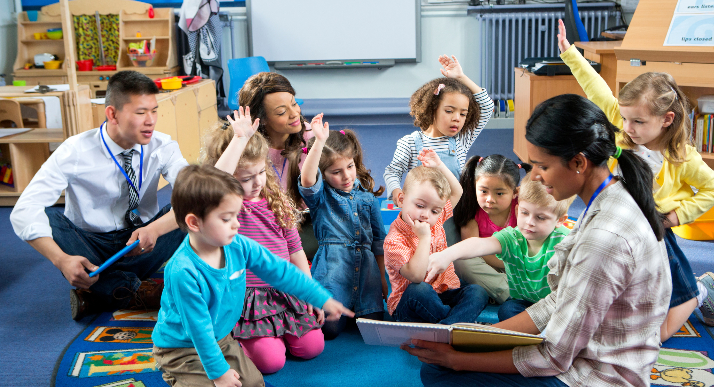 A group of children sitting on the floor in a classroom